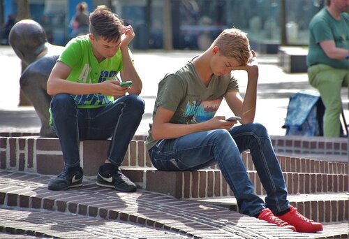 Zwei Jugendliche schauen auf ihre Smartphones